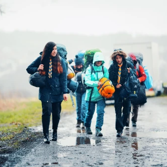 Pfadrangerinnen wandern schwerbepackt im Regen